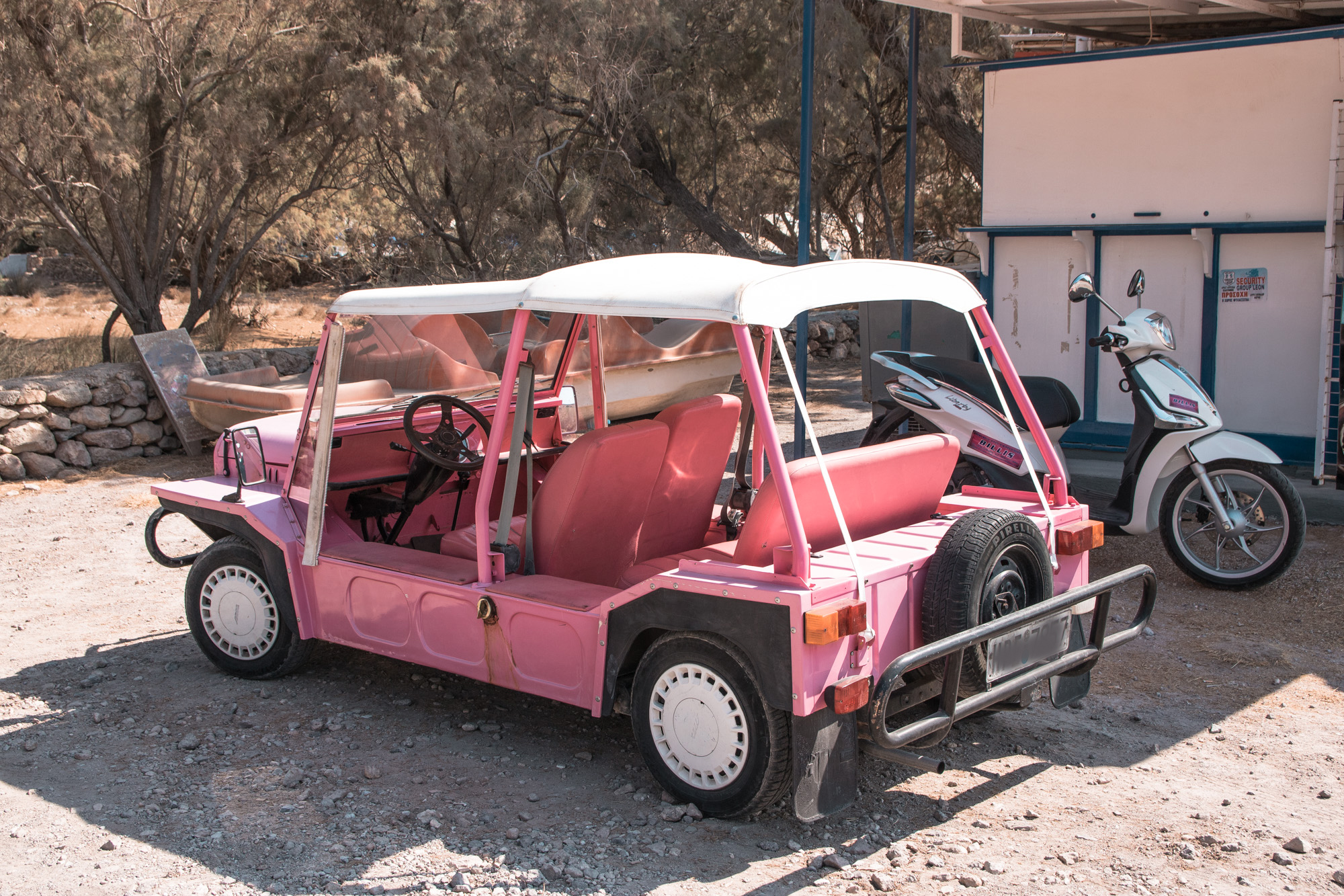 Rosaroter Mini Moke, ein älteres Auto das aussieht wie ein niedriggelegter Jeep, entdeckt beim Inselhüpfen auf Patmos